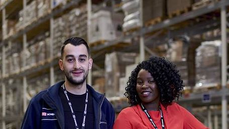A male and a female logistics expert working for DB Schenker are standing in a warehouse
