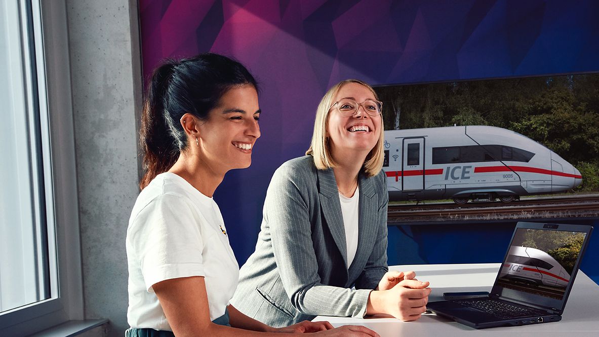 Zwei Digital Consultants sitzen im Besprechungsraum vor einem Laptop