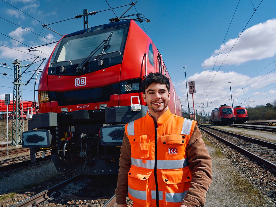 Ein Lokrangierführer in Warnweste steht vor einem Triebwagen des Güterverkehrs