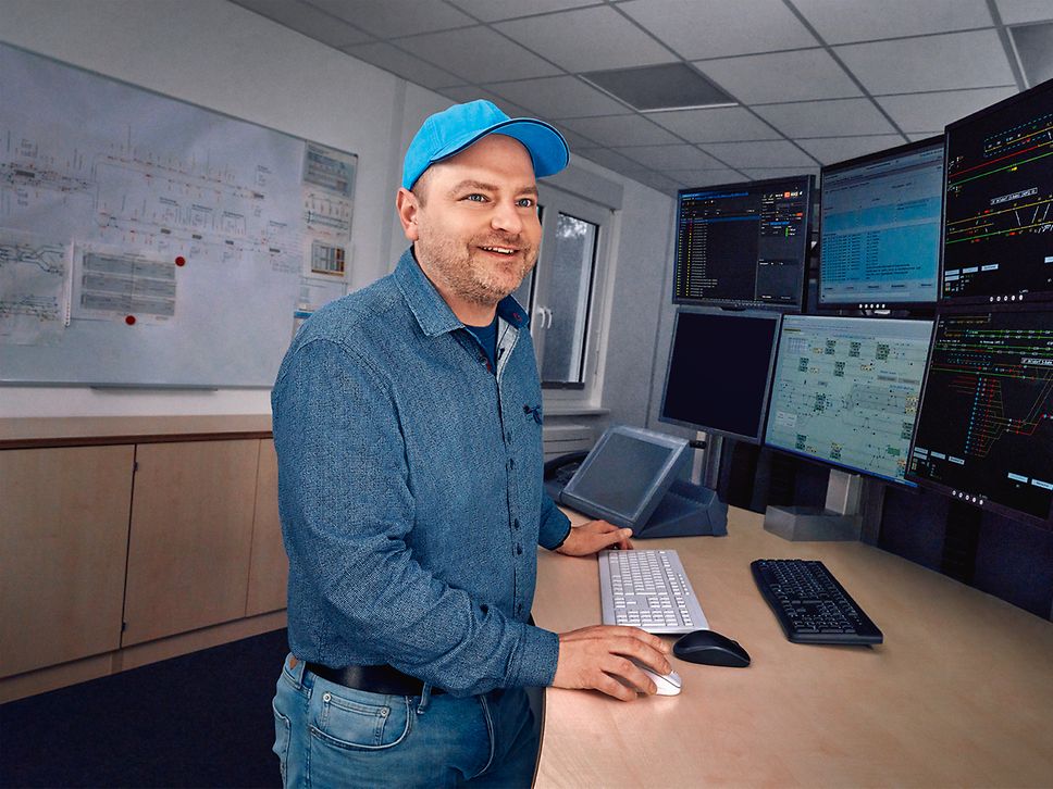 Ein Fahrdienstleiter arbeitet an acht Bildschirmen des Elektronischen Stellwerks
