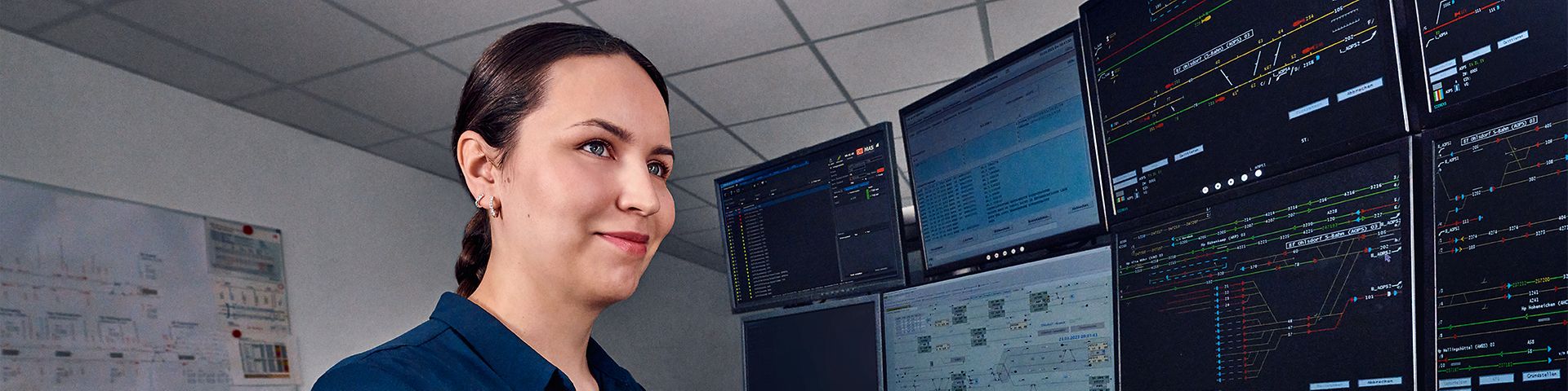 Eine Fahrdienstleiterin arbeitet an acht Bildschirmen des Elektronischen Stellwerks