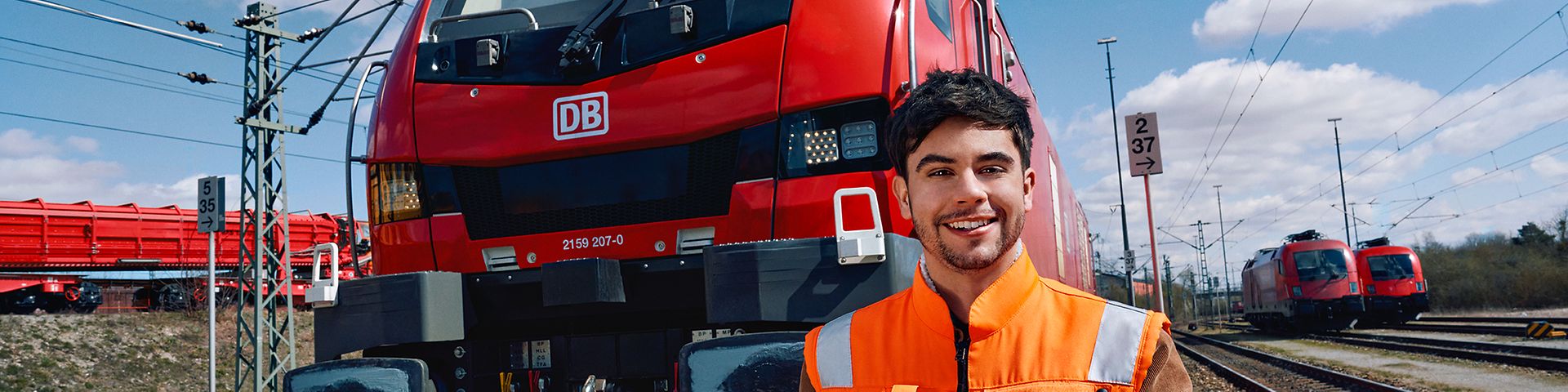 Ein Lokrangierführer in Warnweste steht vor einem Triebwagen des Güterverkehrs