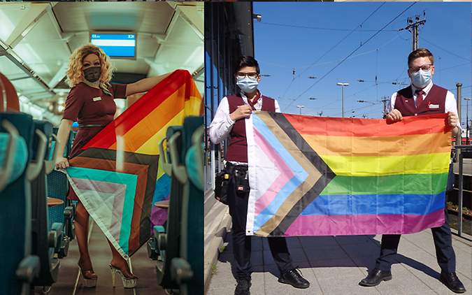 Mitarbeiter in Unternehmensbekleidung am Diversity Tag mit Regenbogenfahnen in den Händen