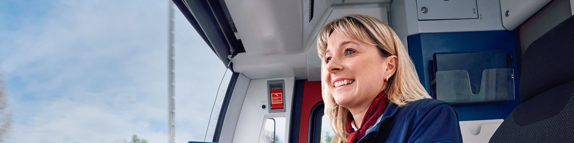 Eine Lokführerin der S-Bahn Berlin sitzt in Unternehmensbekleidung im Führerstand und steuert den Zug