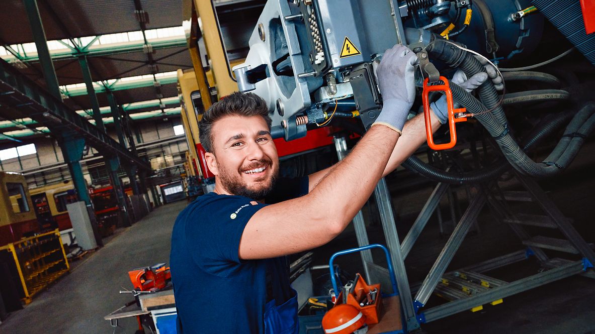 Ein Auszubildender zum Instandhalter repariert im Werk ein Bauteil