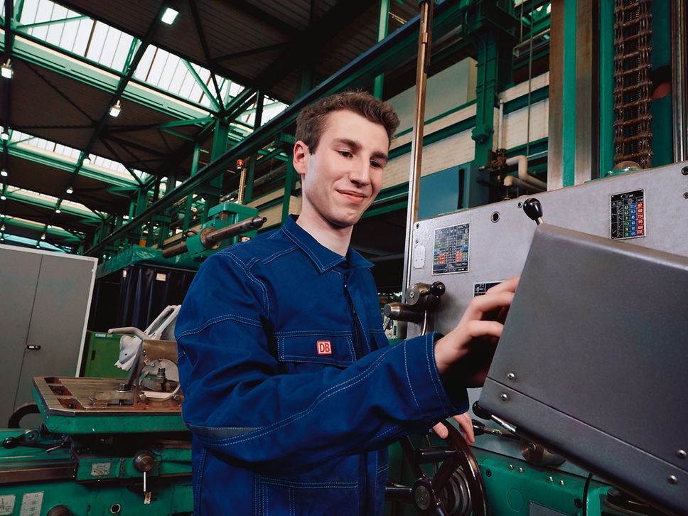 Ein Auszubildender zum Instandhalter bedient im Werk eine Maschine