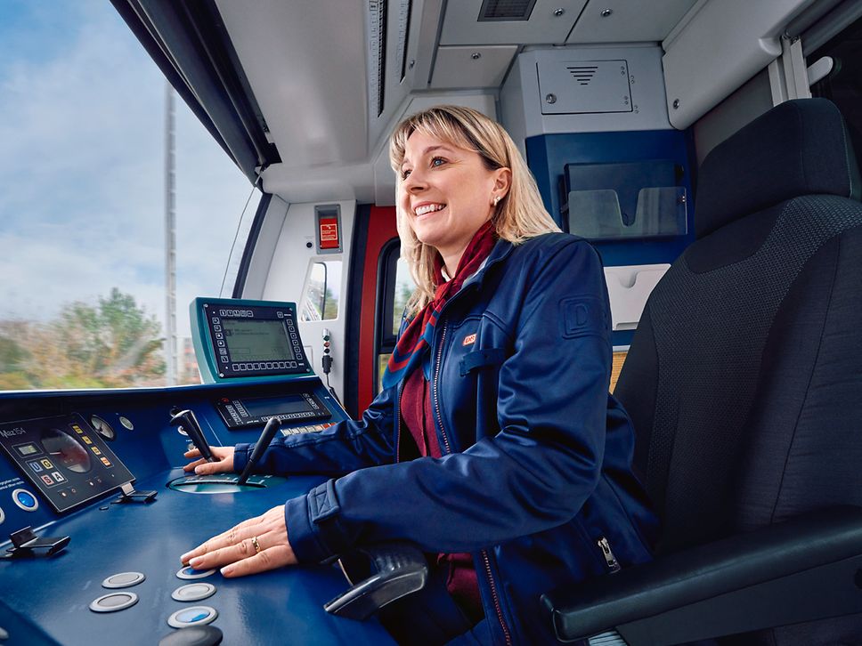 Eine Lokführerin der S-Bahn Berlin sitzt in Unternehmensbekleidung im Führerstand und steuert den Zug