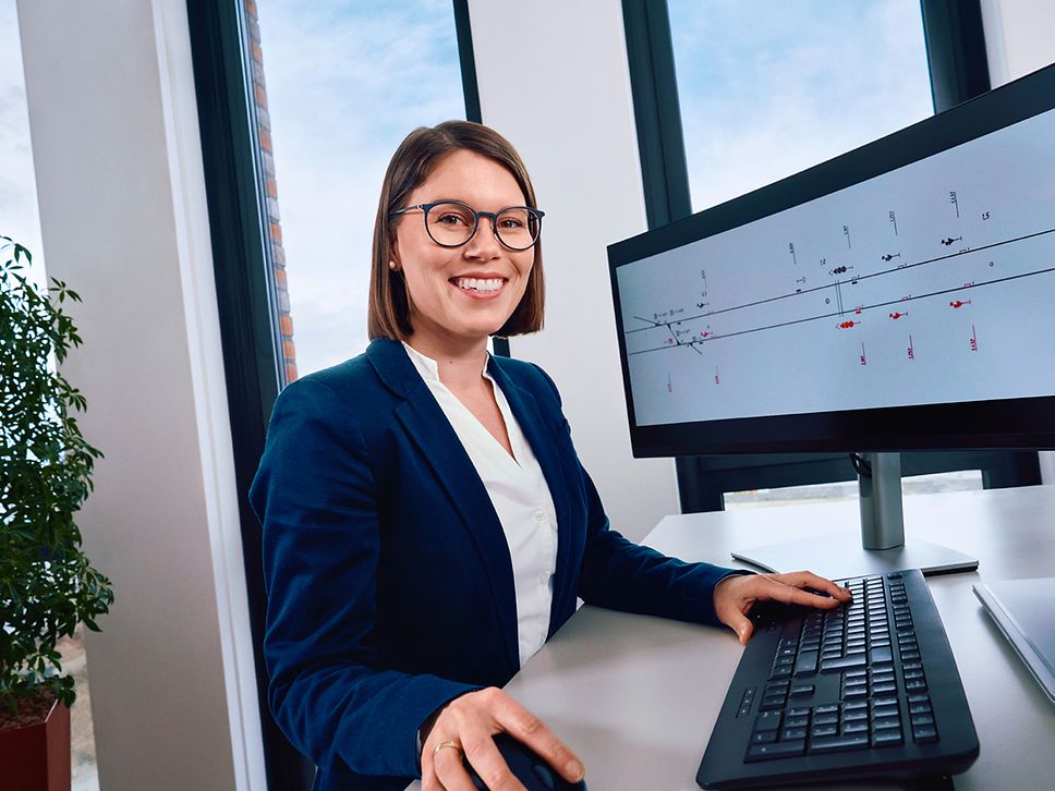 Eine Elektroingenieurin sitzt am Schreibtisch und arbeitet am PC