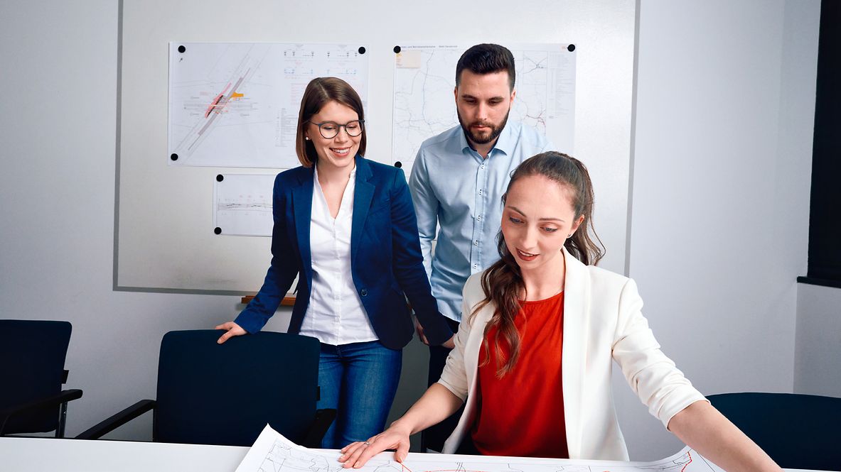 Ein Team aus Ingenieuren prüft im Besprechungsraum gemeinsam Planungsunterlagen