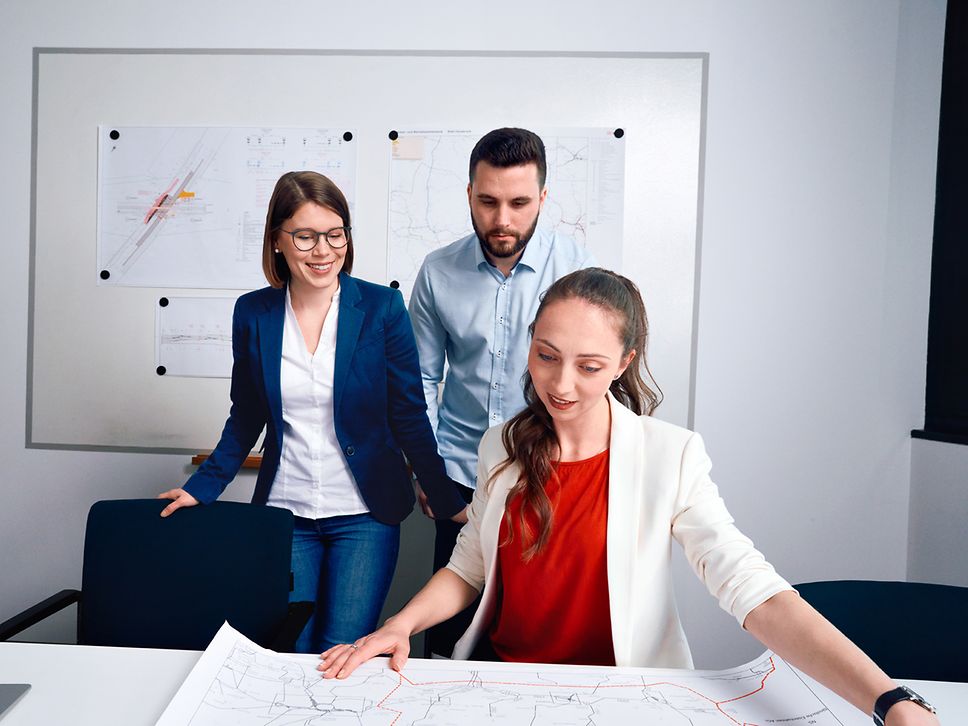 Ein Team aus Ingenieuren prüft im Besprechungsraum gemeinsam Planungsunterlagen