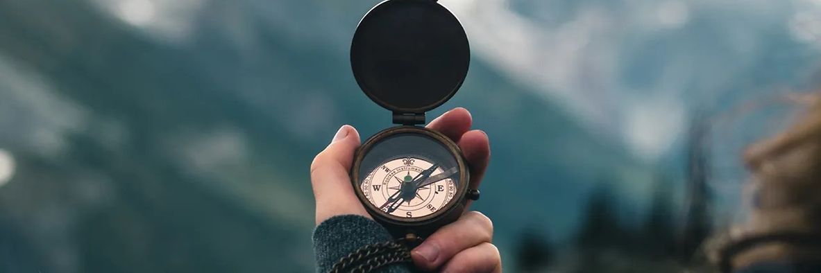 Eine Frau hält in ihrer linken Hand einen Kompass zur Orientierung