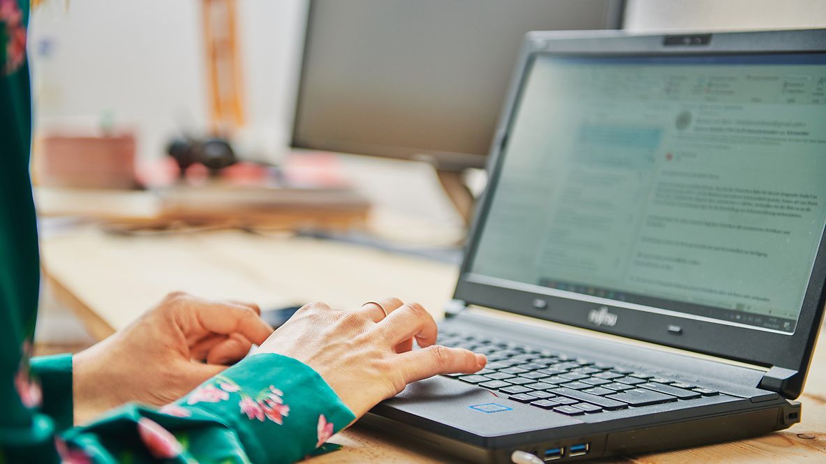 Hände tippen auf einer Laptoptastatur