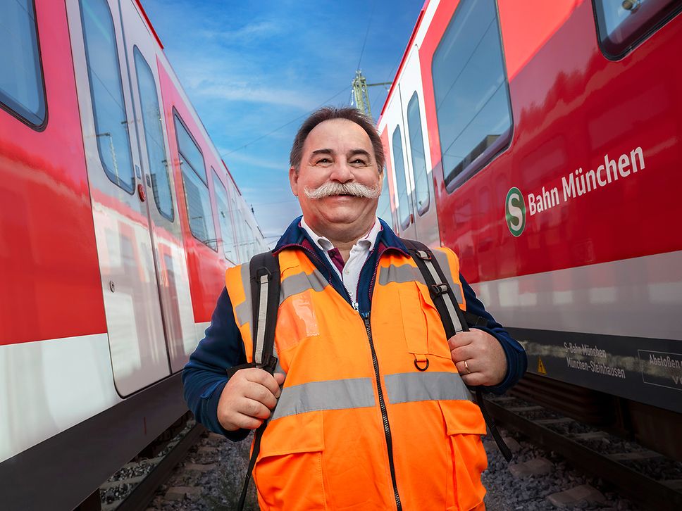 Ein Lokführer in Warnweste läuft zwischen zwei stehenden S-Bahnen in München