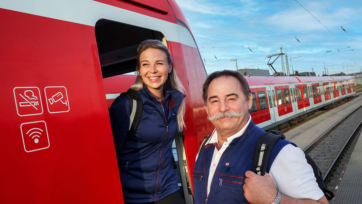 Ein Lokführer und eine Lokführerin neben dem Führerstand einer S-Bahn in München