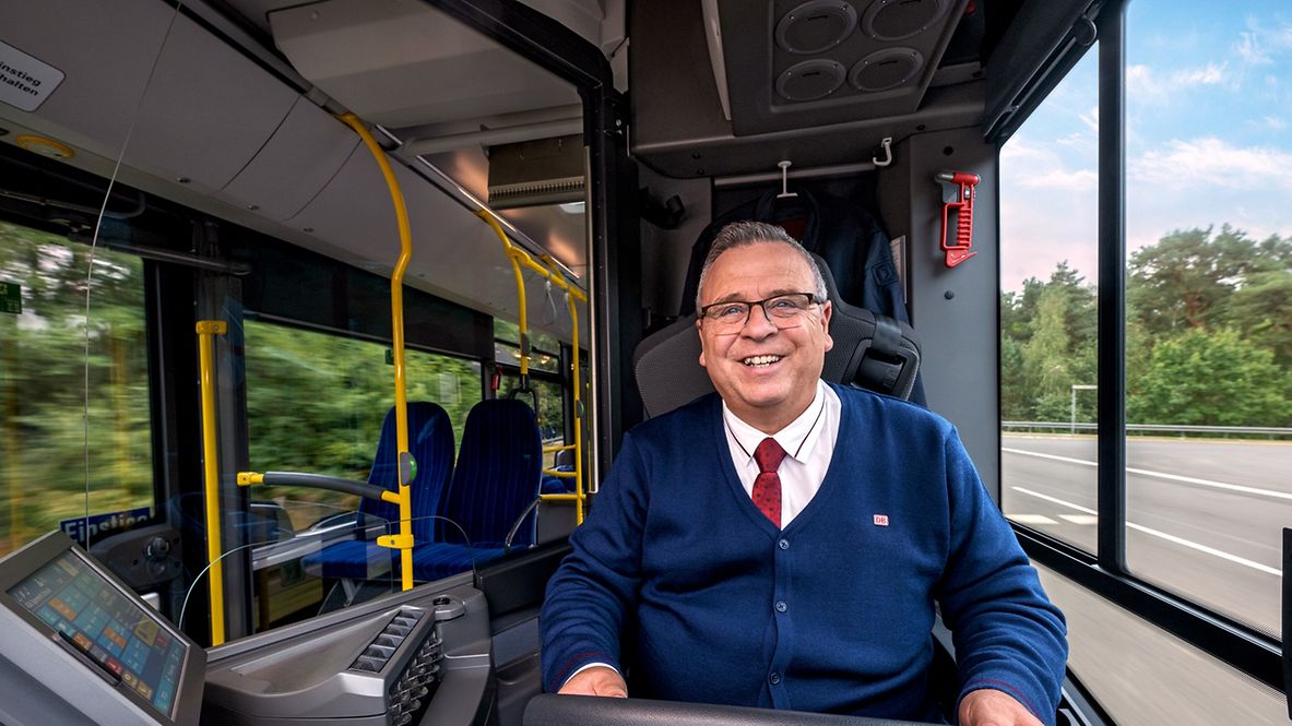 Ein Busfahrer sitzt am Steuer und lenkt einen Bus