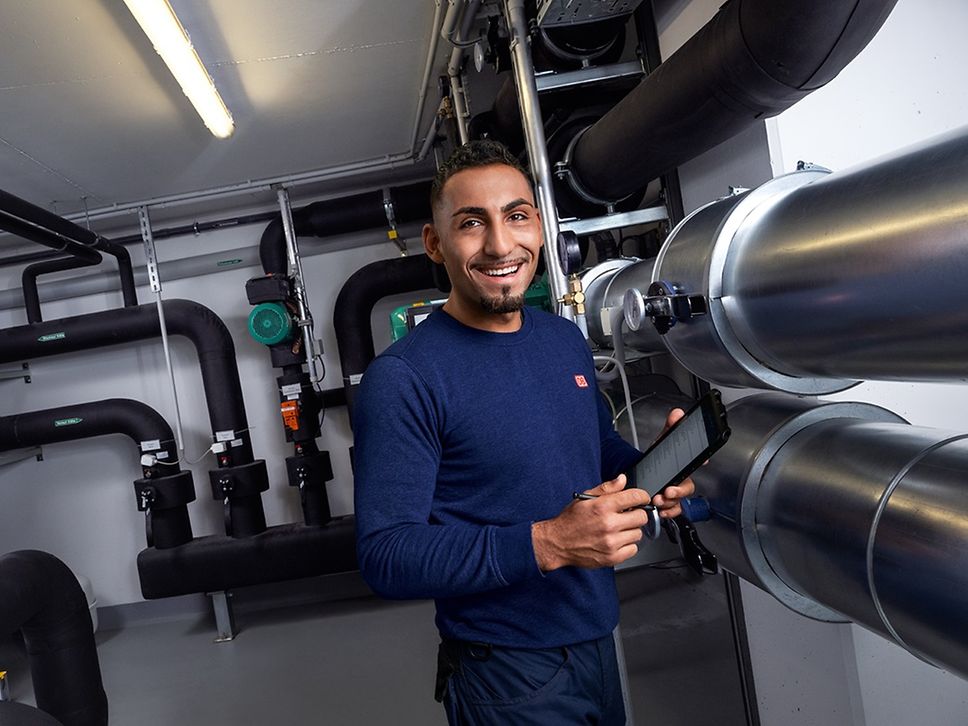 Ein Elektroniker für Betriebstechnik in Ausbildung prüft die haustechnischen Anlagen