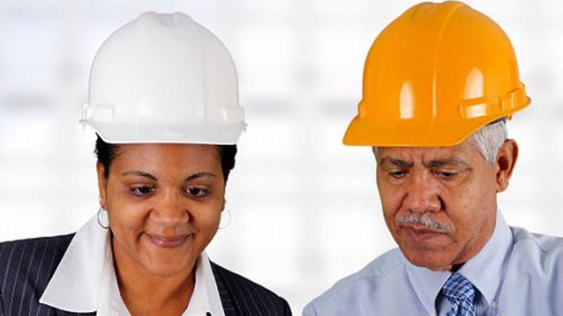 Two civil engineers from DB Engineering & Consulting with protective helmets on their heads are studying construction plans