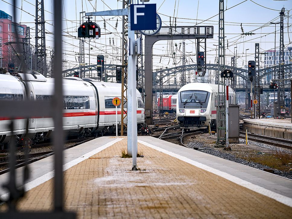 Zwei Züge bei der Ein- und Ausfahrt in einen Bahnhof