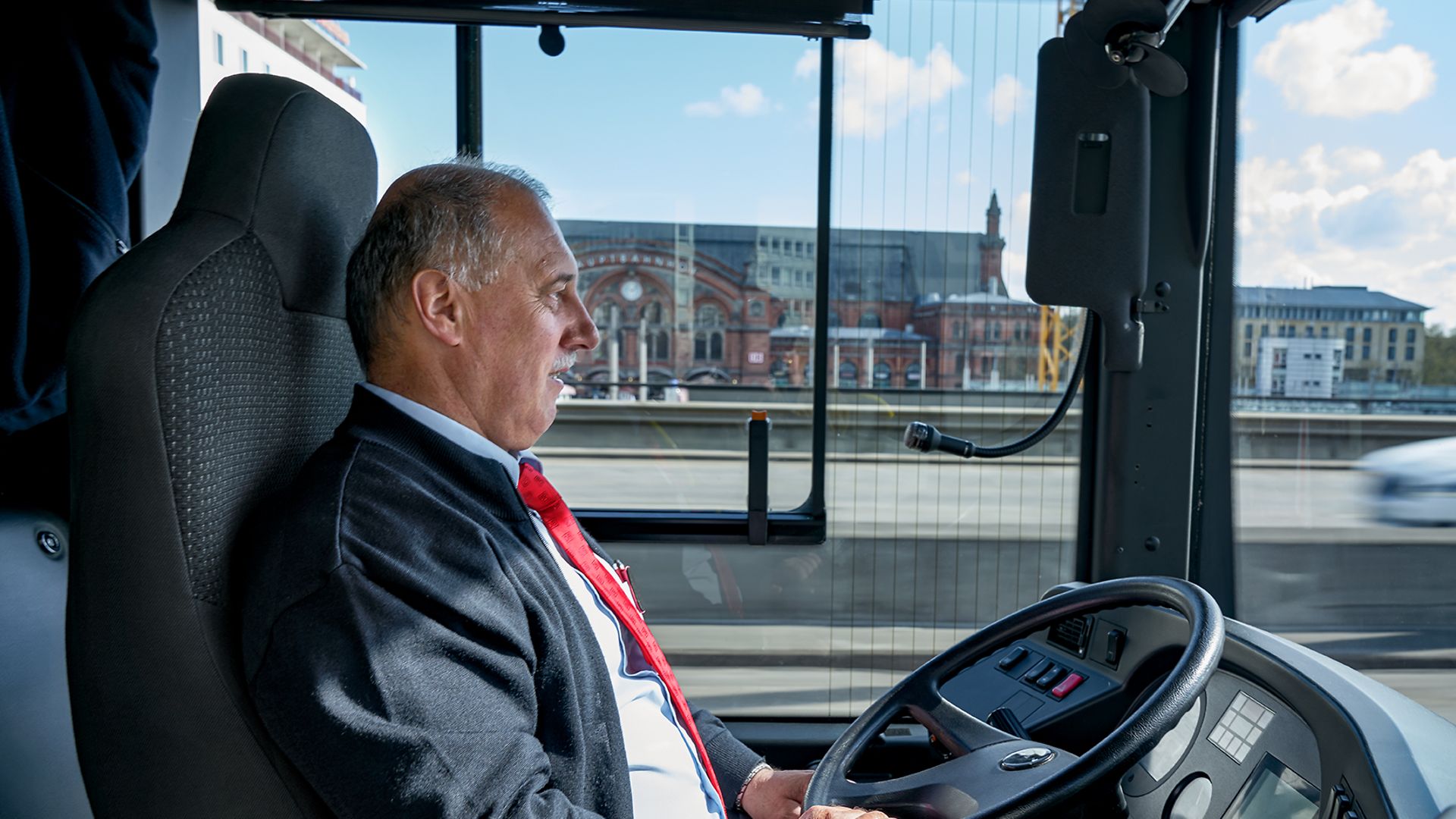 Ein Busfahrer sitzt im Fahrersitz und steuert einen Bus