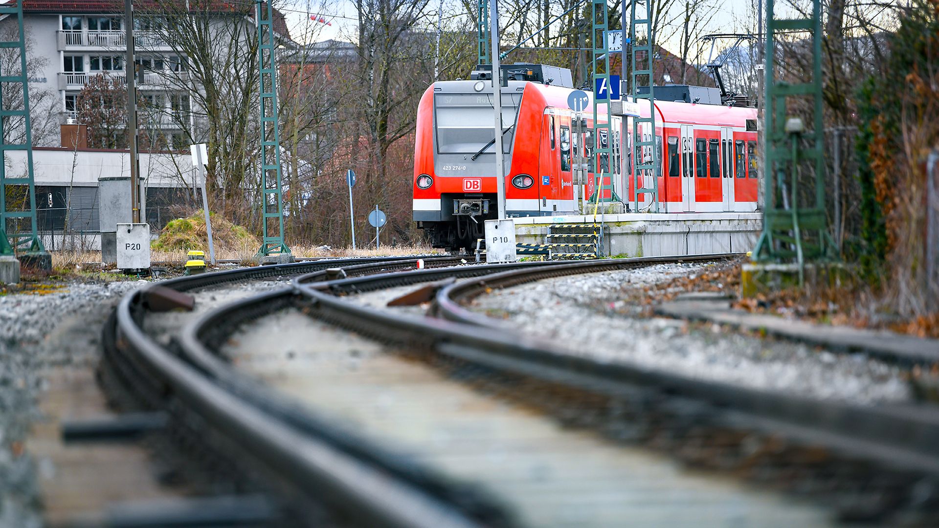 Ein roter Regionalzug fährt auf dem Gleis