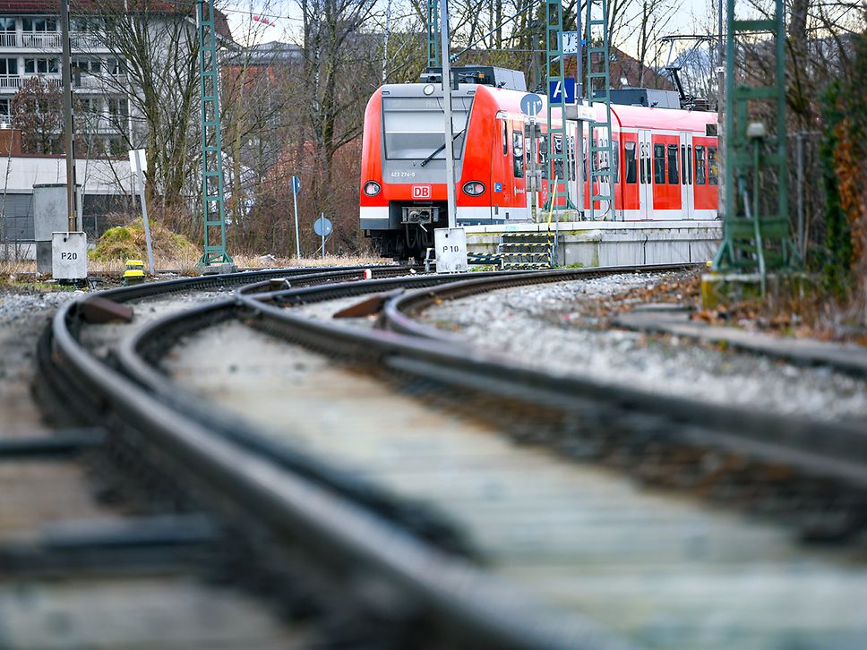 Ein roter Regionalzug fährt auf dem Gleis