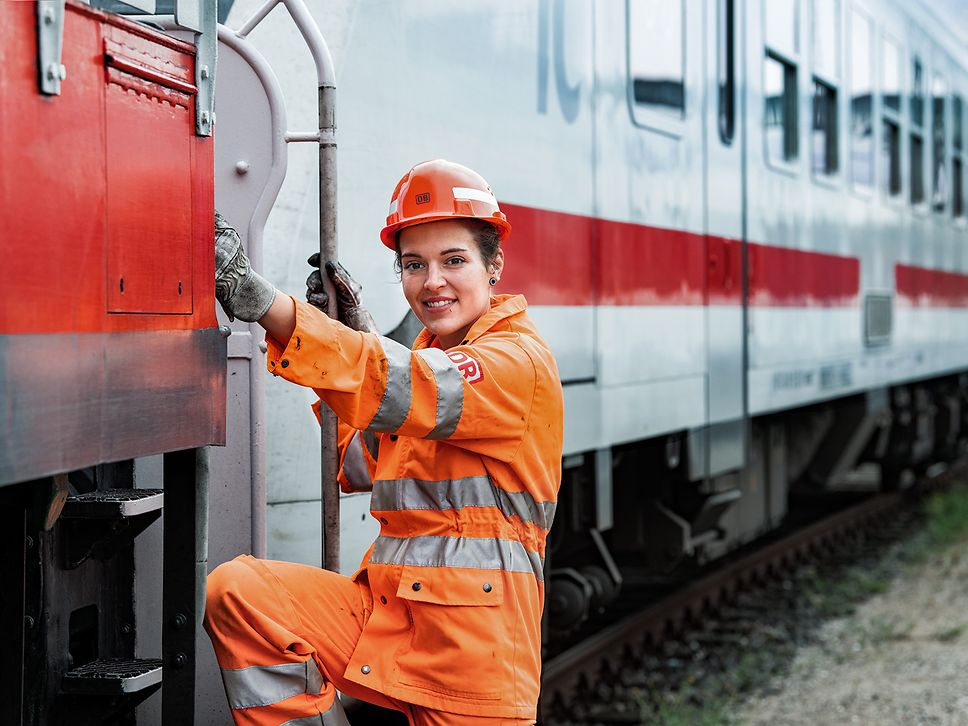 Eine Lokrangierführerin in Warnkleidung und mit Schutzhelm steigt in den Führerstand
