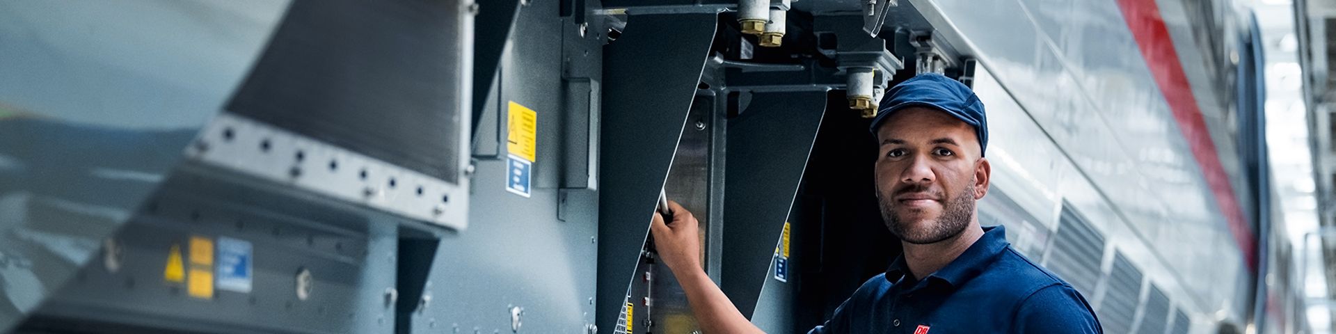 Ein Elektroniker prüft die elektronischen Schutzvorrichtungen des Zuges an der Zugaußenseite