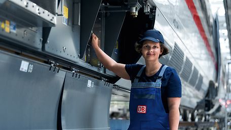 Eine Elektronikerin prüft die elektronischen Schutzvorrichtungen des Zuges an der Zugaußenseite